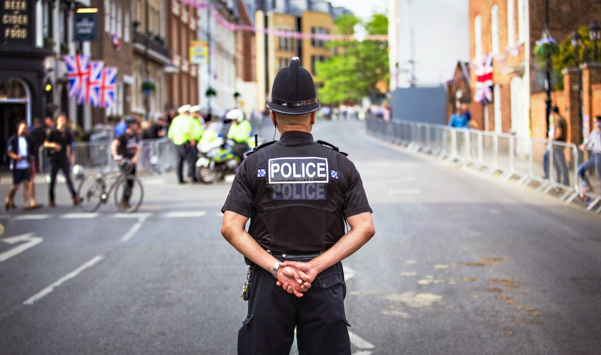 policeman standing in middle of street. His back is to the camera