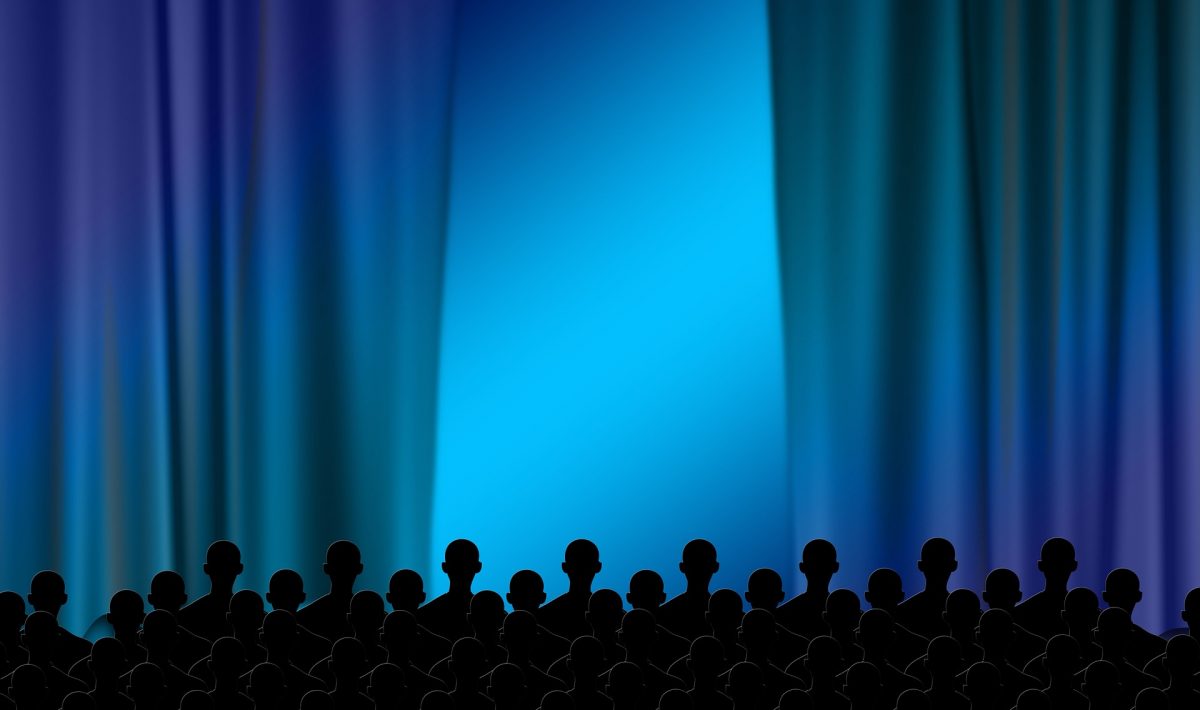 blue curtains in front of a blue backdrop and the black silhouettes of people in front